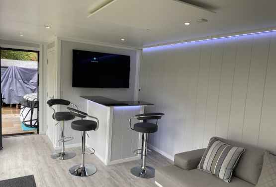 family entertainment room with bar , tv and inferred heater on the Hampshire